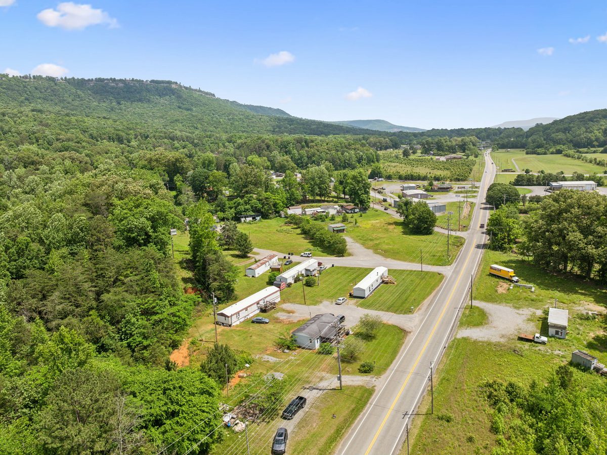 Aerial view along Main Street (US Highway 41) with the community at right and a wooded ridge behind