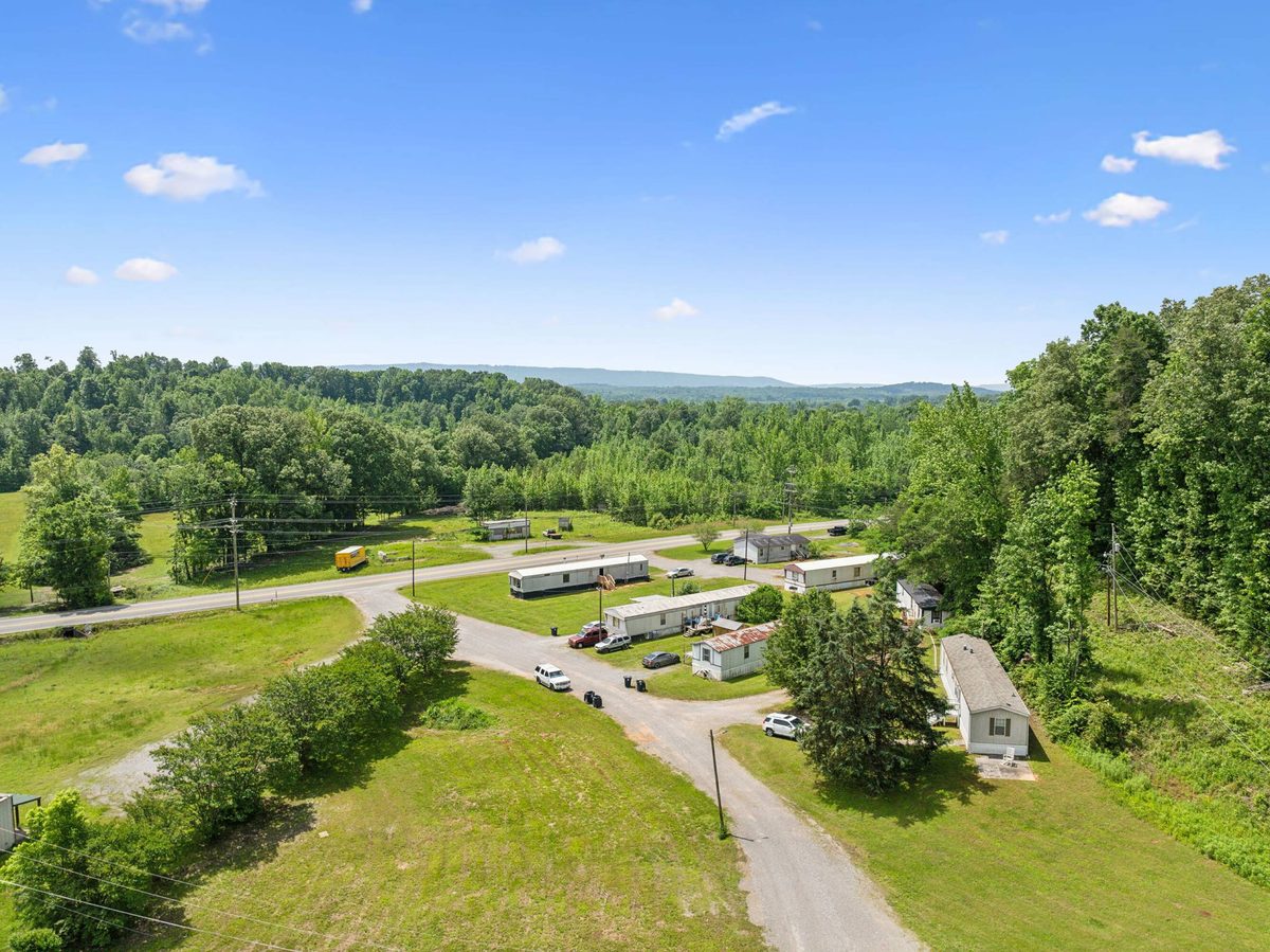 Aerial view of the community's homes and gravel drives against the wooded hillside