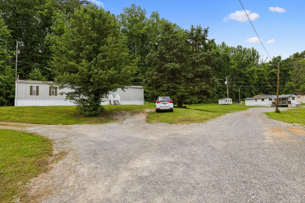 Single-wide home and gravel parking area along the interior drive
